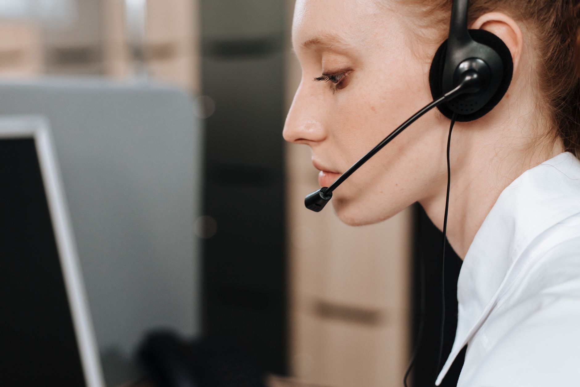 A dispatcher wearing a headset at her desk